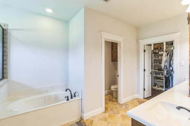 210 Walker Ct N, Waxahachie, TX 75167 - bathroom with a garden tub, double vanity, a walk in closet, and recessed lighting