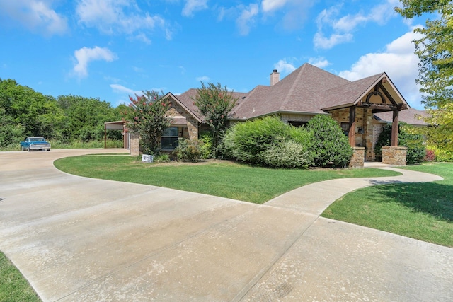 210 Walker Ct N, Waxahachie, TX 75167 - view of front of property featuring a front lawn, concrete driveway, a chimney, stone siding, and a shingled roof