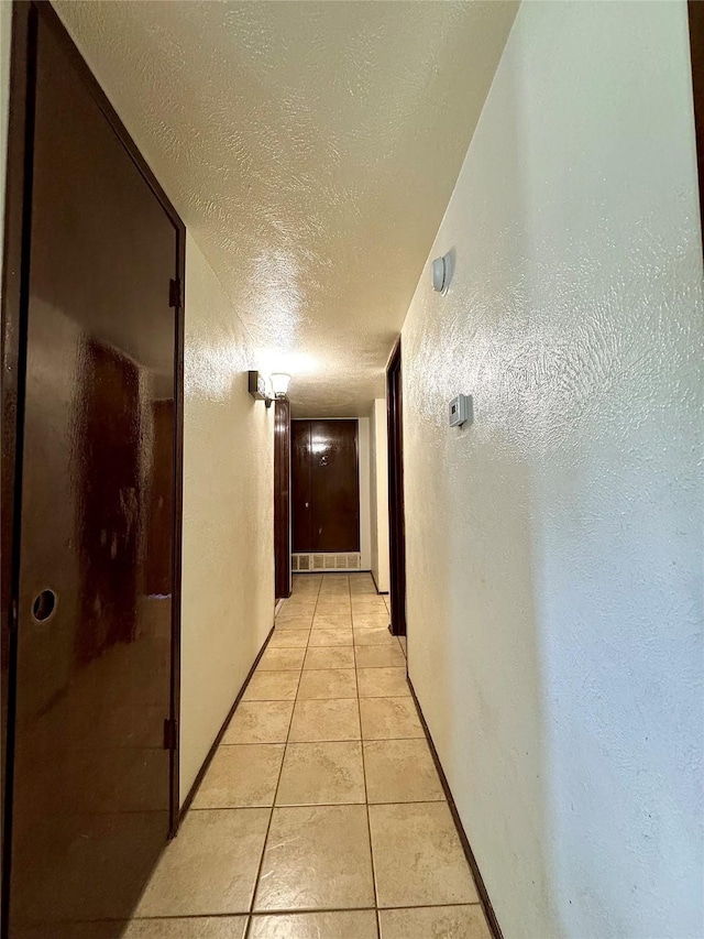 1125 Siebold Ct, Mesquite, TX 75150 - hall with a textured ceiling, light tile patterned floors, and a textured wall