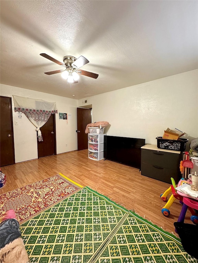 1125 Siebold Ct, Mesquite, TX 75150 - rec room with wood finished floors, a ceiling fan, and a textured ceiling