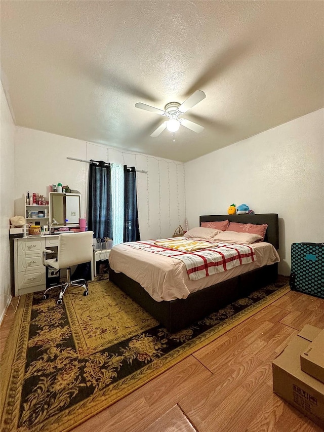 1125 Siebold Ct, Mesquite, TX 75150 - bedroom featuring wood finished floors, an office area, a textured ceiling, and a ceiling fan