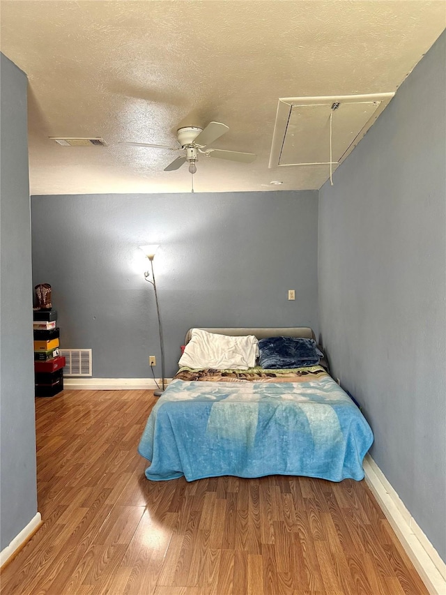 1125 Siebold Ct, Mesquite, TX 75150 - bedroom with attic access, wood finished floors, a ceiling fan, and a textured ceiling