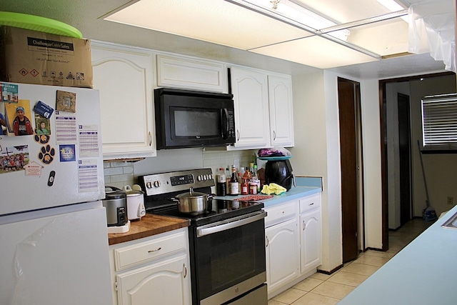 1125 Siebold Ct, Mesquite, TX 75150 - kitchen featuring black microwave, stainless steel electric range oven, freestanding refrigerator, white cabinetry, and light tile patterned floors