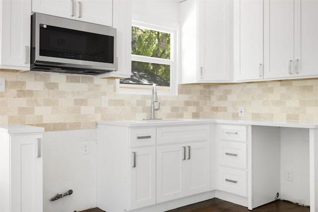 2267 Tealford Dr, Dallas, TX 75228 - kitchen with stainless steel microwave, light countertops, tasteful backsplash, and white cabinetry