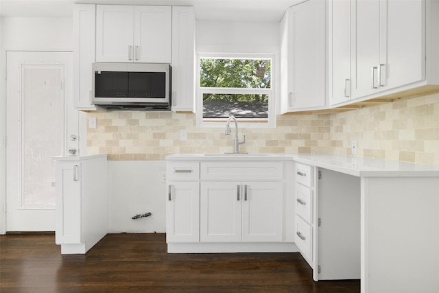 2267 Tealford Dr, Dallas, TX 75228 - kitchen with stainless steel microwave, light countertops, white cabinets, and dark wood-style flooring