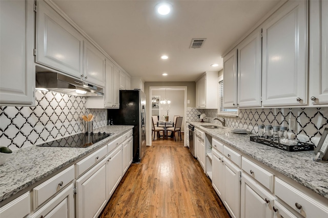 4053 Winfield Ave, Fort Worth, TX 76109 - kitchen with under cabinet range hood, appliances with stainless steel finishes, white cabinetry, backsplash, and recessed lighting