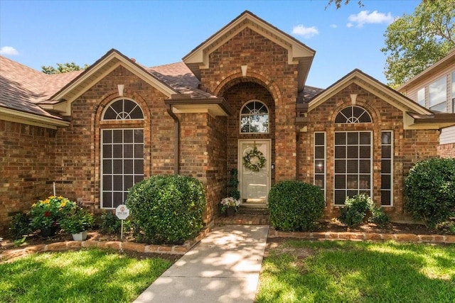 6321 Cobblestone Ln, Arlington, TX 76001 - entrance to property with brick siding, roof with shingles, and a yard