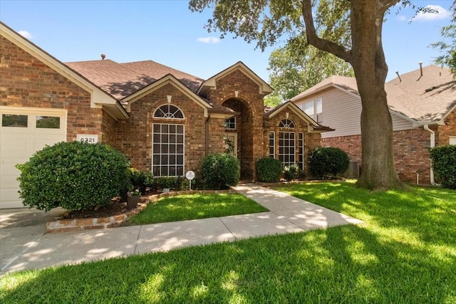 6321 Cobblestone Ln, Arlington, TX 76001 - traditional-style house with brick siding, a front lawn, a shingled roof, and a garage