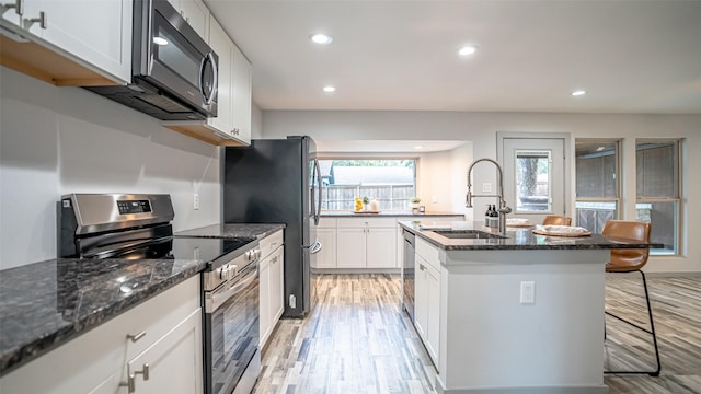 1031 Oak Hurst Dr, Grapevine, TX 76051 - kitchen with stainless steel appliances, light wood-style floors, recessed lighting, dark stone countertops, and a breakfast bar