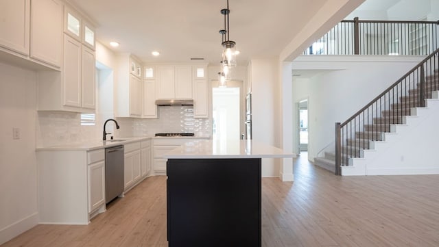 1032 Meadowlark, Forney, TX 75126 - kitchen with stainless steel dishwasher, light wood finished floors, a kitchen island, under cabinet range hood, and tasteful backsplash