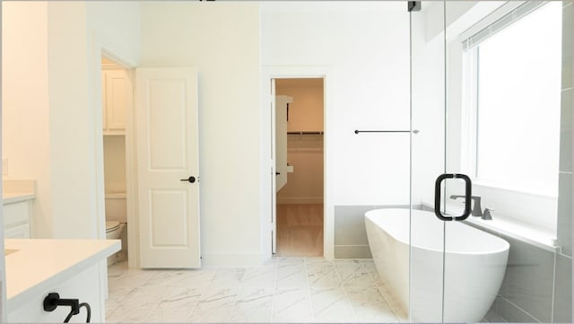 1032 Meadowlark, Forney, TX 75126 - full bathroom featuring vanity, a soaking tub, marble look tiles, and a spacious closet