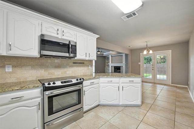 1208 Homestead St, Flower Mound, TX 75028 - kitchen with stainless steel appliances, decorative backsplash, white cabinetry, light tile patterned floors, and a peninsula
