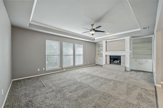 1208 Homestead St, Flower Mound, TX 75028 - unfurnished living room with a tray ceiling, ceiling fan, ornamental molding, carpet floors, and a brick fireplace