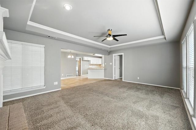 1208 Homestead St, Flower Mound, TX 75028 - unfurnished living room featuring a tray ceiling, ornamental molding, ceiling fan, and light colored carpet