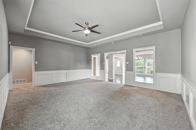 1208 Homestead St, Flower Mound, TX 75028 - carpeted empty room with a raised ceiling, a ceiling fan, a wainscoted wall, a chandelier, and a decorative wall