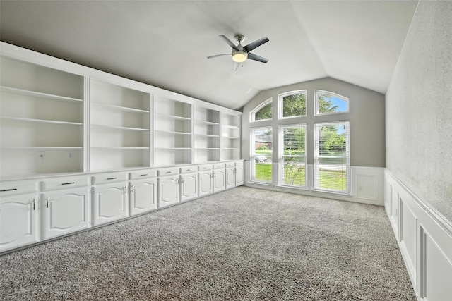 1208 Homestead St, Flower Mound, TX 75028 - spare room featuring vaulted ceiling, a ceiling fan, carpet flooring, wainscoting, and a decorative wall