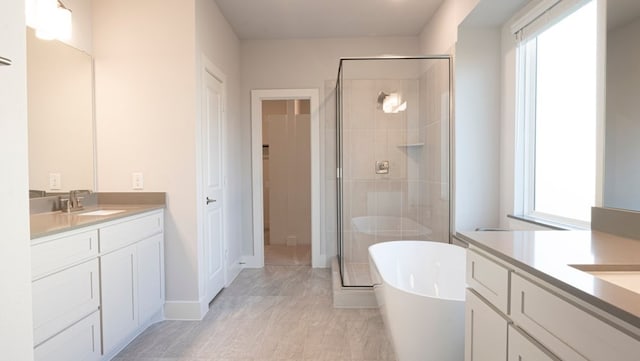 850 Blue Heron Dr, Forney, TX 75126 - bathroom featuring two vanities, a shower stall, and a freestanding tub