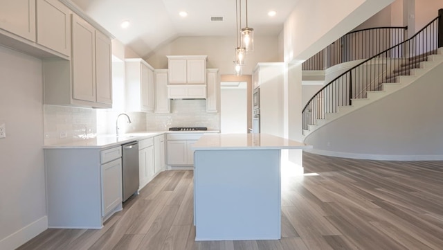 850 Blue Heron Dr, Forney, TX 75126 - kitchen featuring a kitchen island, light countertops, light wood-style floors, gas cooktop, and tasteful backsplash