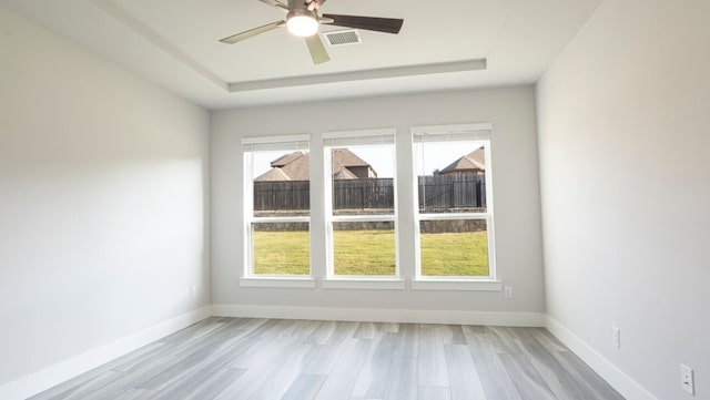 850 Blue Heron Dr, Forney, TX 75126 - empty room with a tray ceiling, light wood-type flooring, and a ceiling fan