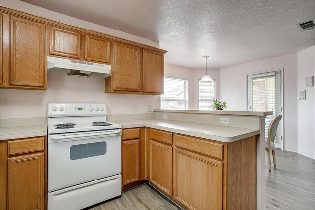 953 Mesa Vista Dr, Crowley, TX 76036 - kitchen with white range with electric cooktop, under cabinet range hood, a peninsula, light wood finished floors, and light countertops