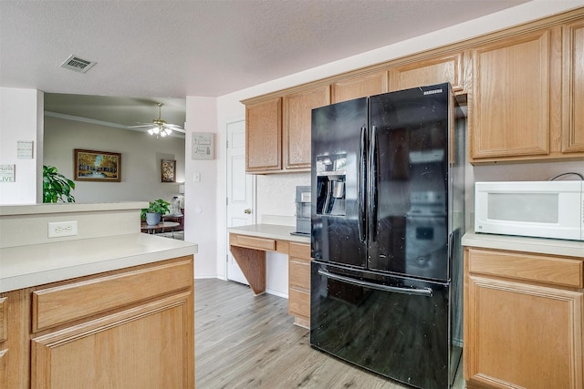 953 Mesa Vista Dr, Crowley, TX 76036 - kitchen with freestanding refrigerator, white microwave, light wood-style flooring, a ceiling fan, and light countertops