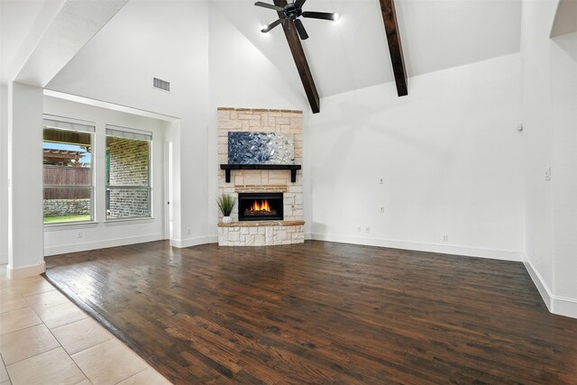 1312 Bluebell Ave, Lantana, TX 76226 - unfurnished living room with high vaulted ceiling, a stone fireplace, wood finished floors, beamed ceiling, and ceiling fan