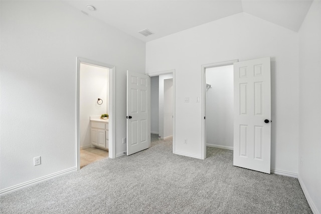 1312 Bluebell Ave, Lantana, TX 76226 - unfurnished bedroom with a walk in closet, light carpet, connected bathroom, and lofted ceiling