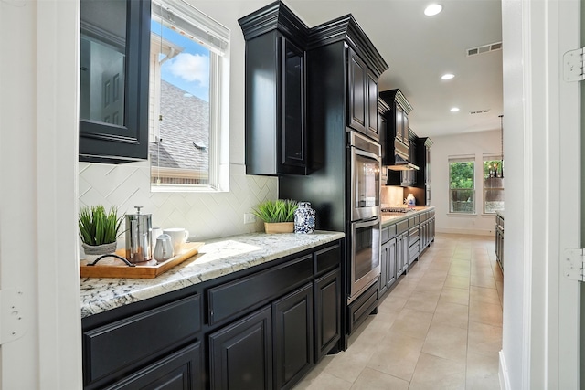 1312 Bluebell Ave, Lantana, TX 76226 - kitchen featuring dark cabinetry, stainless steel appliances, decorative backsplash, recessed lighting, and light tile patterned flooring