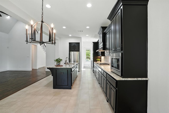 1312 Bluebell Ave, Lantana, TX 76226 - kitchen with appliances with stainless steel finishes, dark cabinets, light stone counters, a chandelier, and recessed lighting