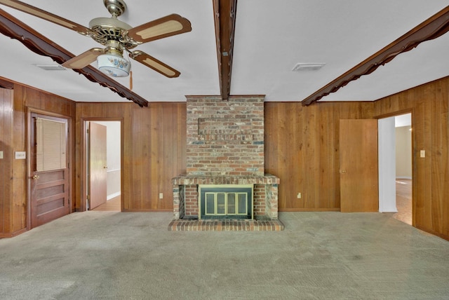 3053 Pines Rd, Shreveport, LA 71119 - unfurnished living room with wood walls, beam ceiling, ceiling fan, carpet flooring, and a brick fireplace