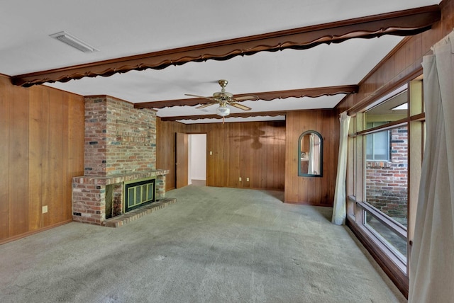 3053 Pines Rd, Shreveport, LA 71119 - unfurnished living room with wooden walls, beam ceiling, carpet floors, a brick fireplace, and ceiling fan