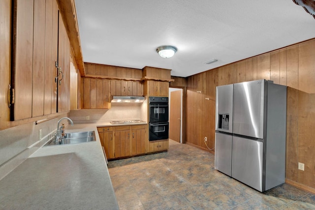 3053 Pines Rd, Shreveport, LA 71119 - kitchen featuring stainless steel fridge with ice dispenser, wood walls, under cabinet range hood, electric stovetop, and light countertops
