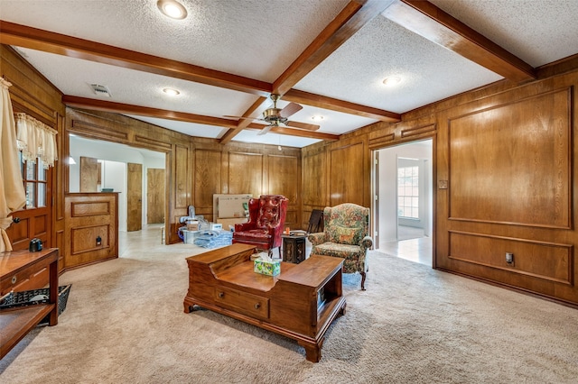 4645 Pecan Place Dr, Mckinney, TX 75071 - living area featuring a textured ceiling, light colored carpet, beam ceiling, wood walls, and ceiling fan