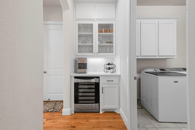 5705 Heron Dr E, Colleyville, TX 76034 - washroom with wine cooler, washer / clothes dryer, cabinet space, a bar, and light wood-type flooring