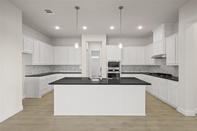 2413 Rams Horn, Waxahachie, TX 75167 - kitchen featuring appliances with stainless steel finishes, dark countertops, under cabinet range hood, decorative backsplash, and recessed lighting