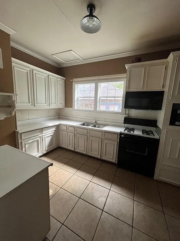 705 W Green St, Palestine, TX 75801 - kitchen with gas stove, light tile patterned floors, crown molding, and light countertops