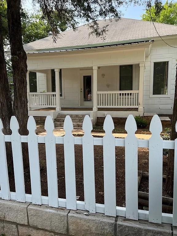 705 W Green St, Palestine, TX 75801 - view of front of home with a porch, a fenced front yard, and roof with shingles