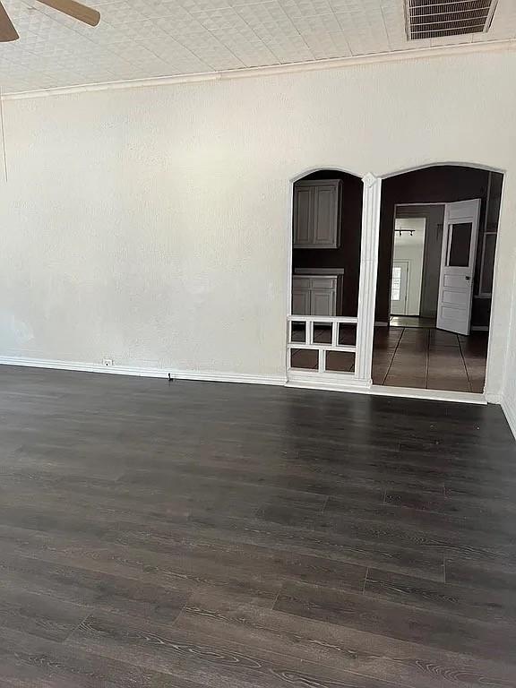 705 W Green St, Palestine, TX 75801 - empty room featuring wood finished floors, arched walkways, and ceiling fan