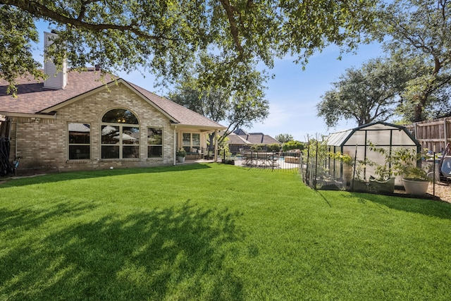4003 Randall Ln, Carrollton, TX 75007 - fenced backyard featuring a greenhouse and an outbuilding