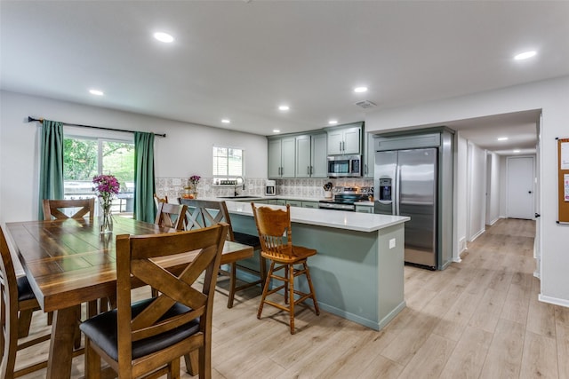 4105 Micki Lynn Ave, Fort Worth, TX 76107 - kitchen featuring stainless steel appliances, light countertops, tasteful backsplash, light wood-style flooring, and recessed lighting