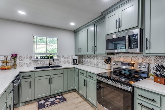 4105 Micki Lynn Ave, Fort Worth, TX 76107 - kitchen featuring appliances with stainless steel finishes, green cabinetry, light wood finished floors, decorative backsplash, and recessed lighting