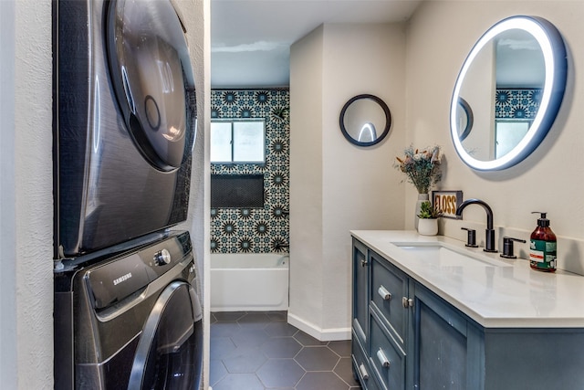 4105 Micki Lynn Ave, Fort Worth, TX 76107 - laundry room featuring stacked washing machine and dryer and dark tile patterned flooring