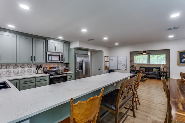4105 Micki Lynn Ave, Fort Worth, TX 76107 - kitchen with appliances with stainless steel finishes, light stone counters, a breakfast bar area, backsplash, and recessed lighting