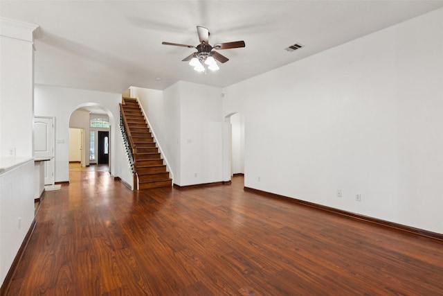 2930 Coteau Way, Dallas, TX 75227 - unfurnished living room featuring arched walkways, a ceiling fan, dark wood finished floors, and stairway