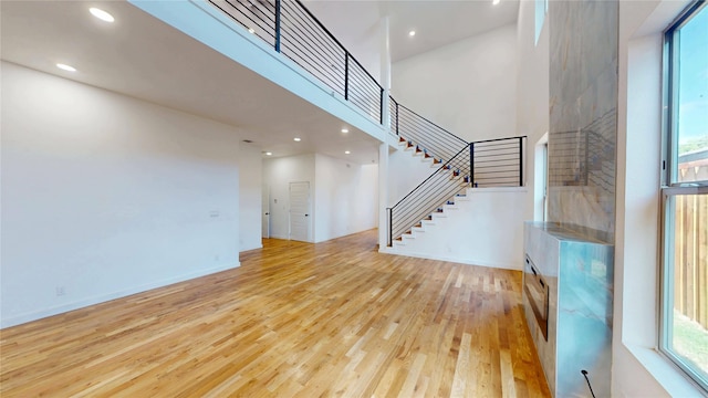3418 Borger St, Dallas, TX 75212 - unfurnished living room featuring light wood-type flooring, stairway, recessed lighting, and a high ceiling