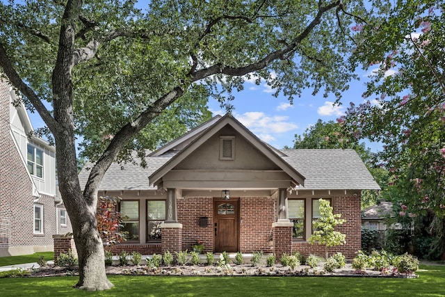 5610 Vanderbilt Ave, Dallas, TX 75206 - english style home featuring brick siding, a front lawn, and a shingled roof