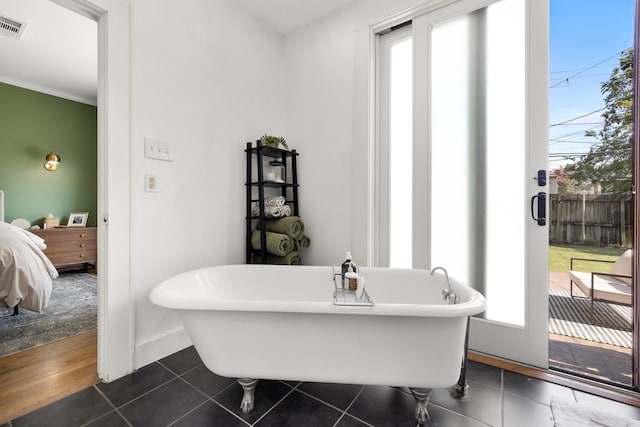 5610 Vanderbilt Ave, Dallas, TX 75206 - ensuite bathroom with healthy amount of natural light, a soaking tub, tile patterned floors, and ornamental molding