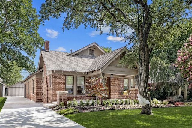 5610 Vanderbilt Ave, Dallas, TX 75206 - tudor-style house featuring brick siding, a chimney, an outbuilding, a front lawn, and a shingled roof