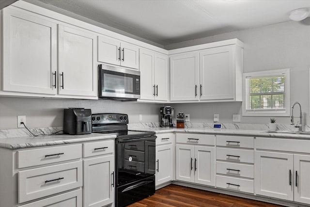 25 W Parnell St, Denison, TX 75020 - kitchen featuring stainless steel microwave, electric range, and white cabinets