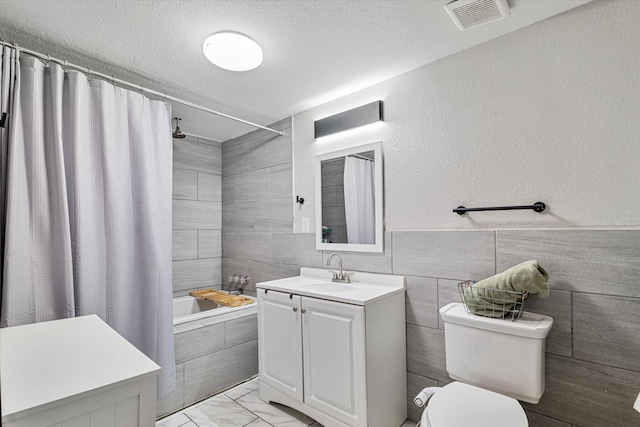25 W Parnell St, Denison, TX 75020 - full bath featuring vanity, marble look tile flooring, tiled shower / bath, and a textured ceiling